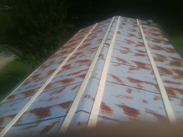 Rusted metal roof panels with new wood purlins before replacement — Storm Damage Roof Repair in Monroe by Roofing Brothers